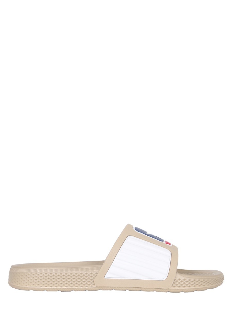 Explore the authentic TELFAR X CONVERSE women's RUBBER SLIDE SANDALS in beige